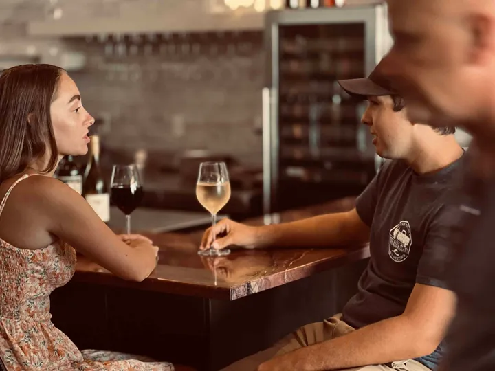 Couple with Wine at a counter top bar.
